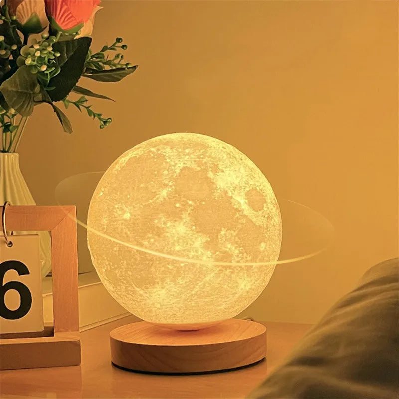 Lunar Orbit illuminated moon resting on its wooden base beside a plant